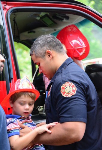 Photo: A U City firefighter lifts a junior trooper into the truck.